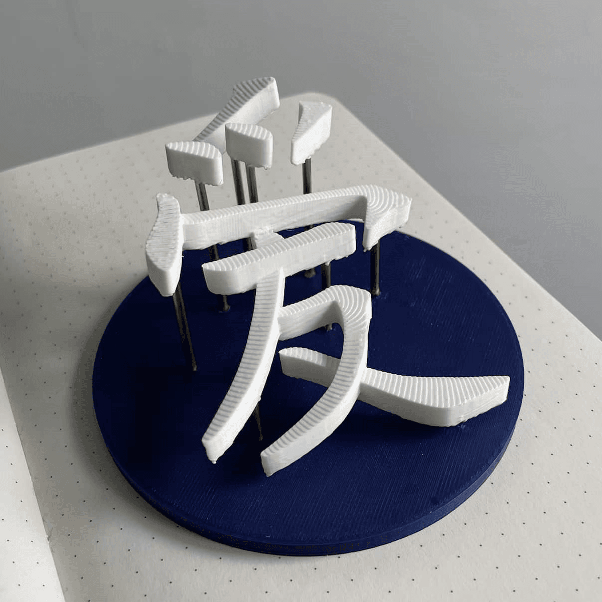 A 3D model of the Chinese character 爱 printed on a stand